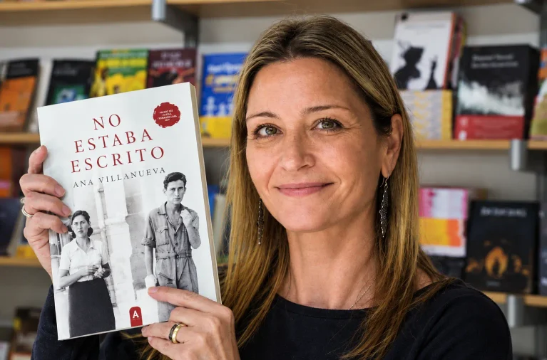 Ana Villanueva sujetando su libro No estaba escrito en una caseta de la Feria del Libro de Valencia